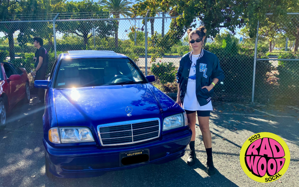 Shannon standing next to blue car outdoors