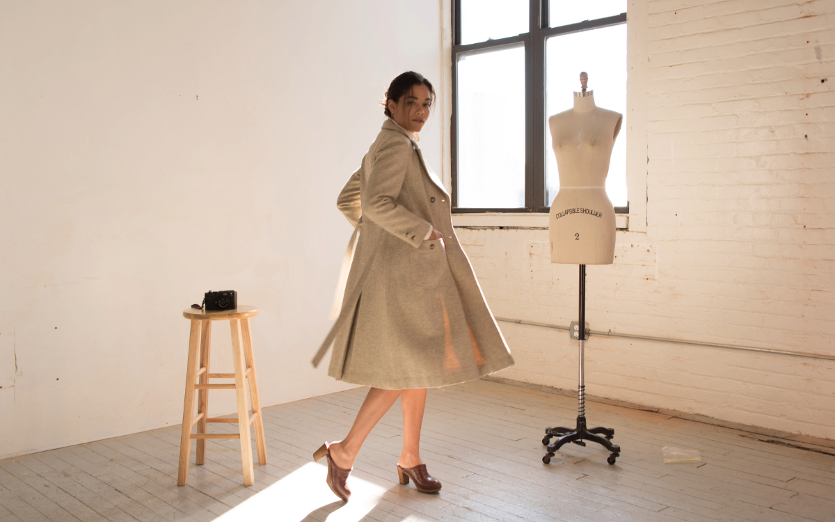 Shannon in trench coat in sun-filled studio
